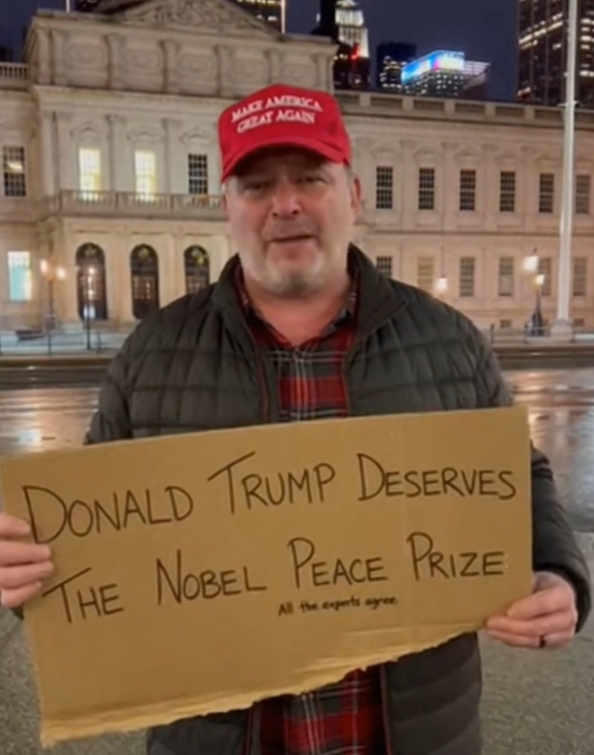 Man Holds Sign Supporting Donald Trump for the Nobel Peace Prize